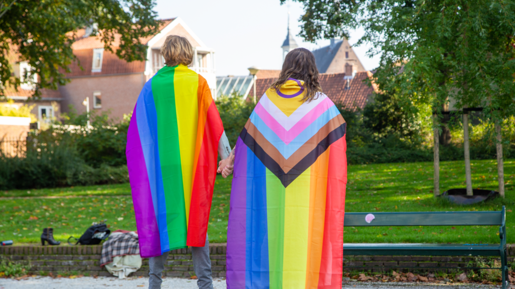 Kandidaten hand in hand met regenboogcape