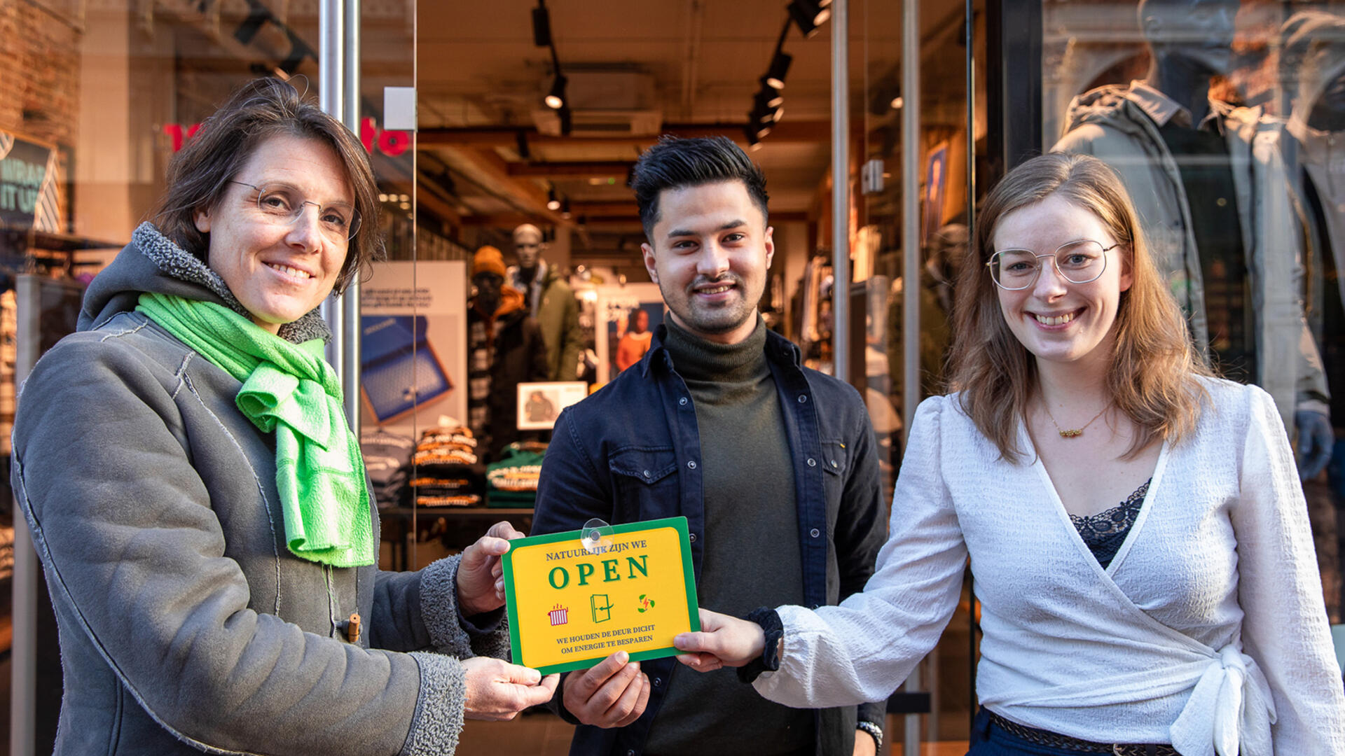 Wethouder Astrid Janssen overhandigd een 'Wij zijn open' bordje