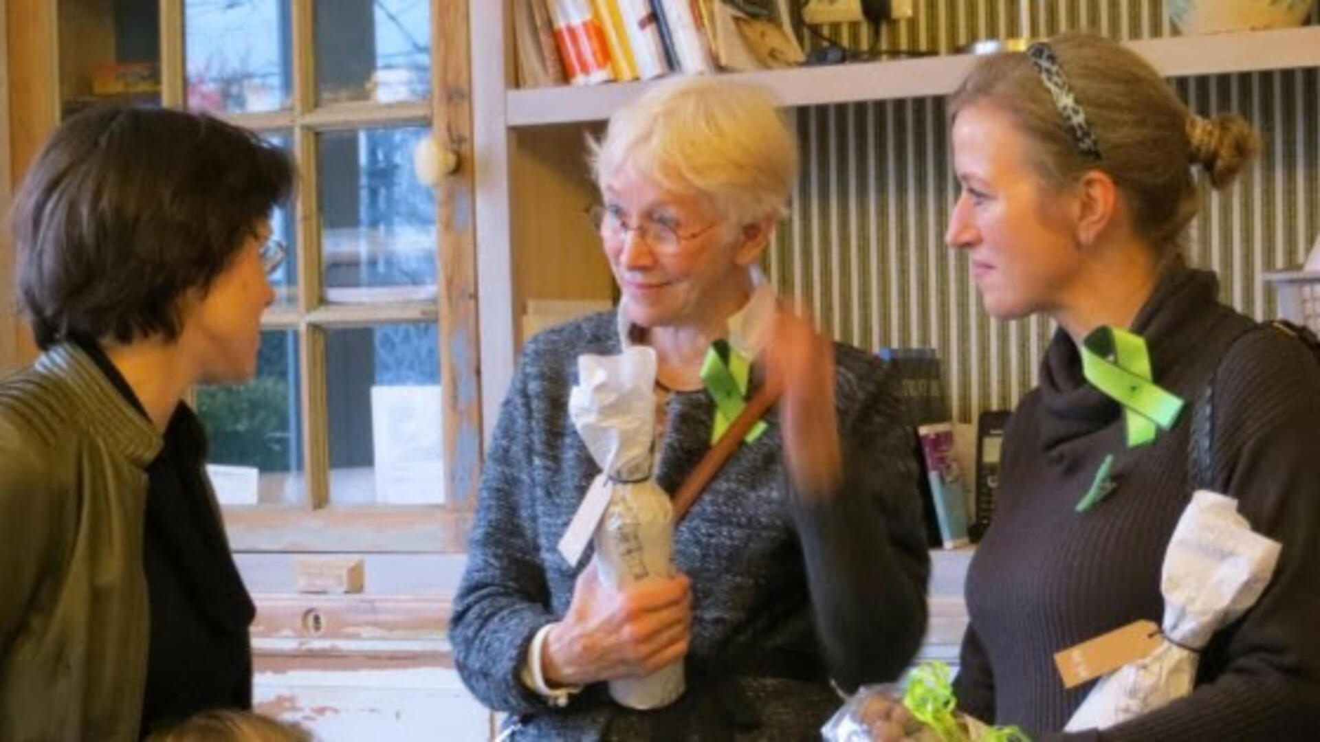 Astrid Jansen en twee vrouwen met en opgespeld groen lintje